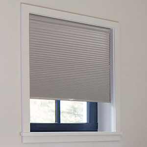 A bedroom window features a Cellular Shade made of 3-4 Caluna Blackout material in Ash for a room darkening effect