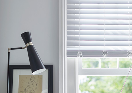 Faux Wood Blinds in Blanc in a white room feature a rigid linear design showing the difference between blinds vs curtains