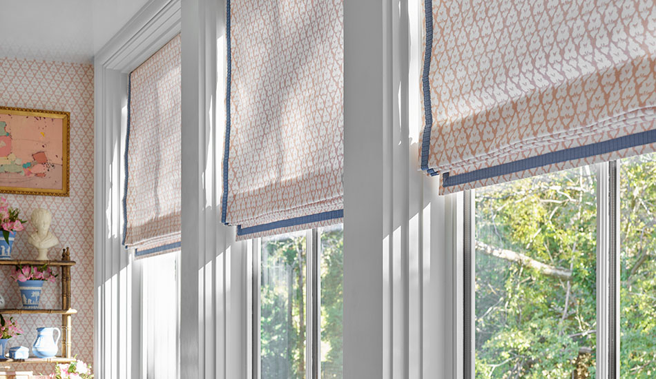 Flat Roman Shades with a pink floral design are sunroom window treatments in a sunroom with matching wallpaper