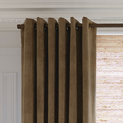 A close up of Grommet Drapery made of Velvet in Camel shows the deep, dramatic folds of this drapery style