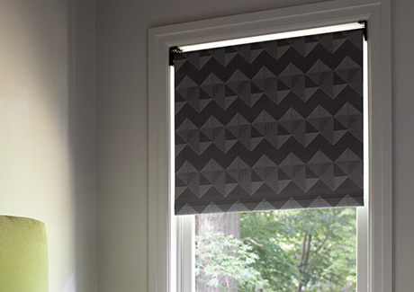 A blackout Roller Shade made of Chilewich Quilt in Tuxedo delivers a geometric pattern and darkening effect to a bedroom