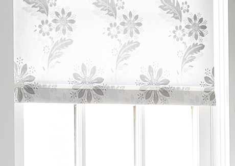 A close up image of Roller Shades for windows made of Florentine in Grigio shows the bottom bar sewn-in to the fabric