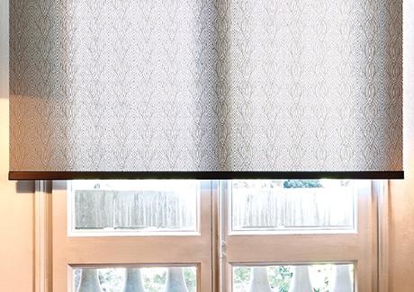 A close up image of Roller Shades for windows made of Tea Leaves in Brown shows the designer bottom bar for a sleek look