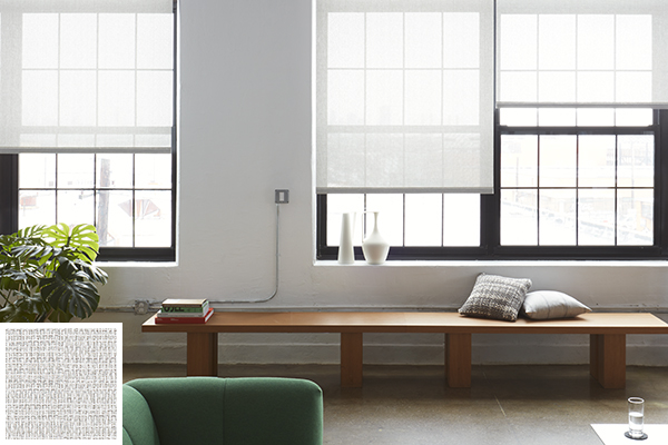 A contemporary living room with minimalist decor outfitted with solar shades for windows in a neutral color of white