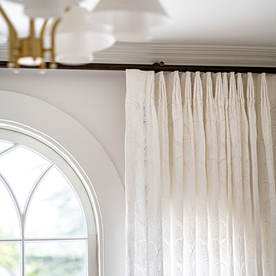 A close up of Tailored Pleat Drapery made of Feather Palm Embroidery in Vintage Lace shows three-finger pleats pinched at the very top